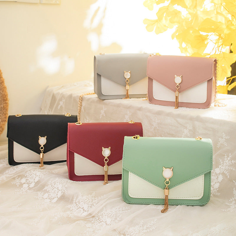 Assorted small square PU crossbody bags in black, wine red, gray, and mint with gold tassels