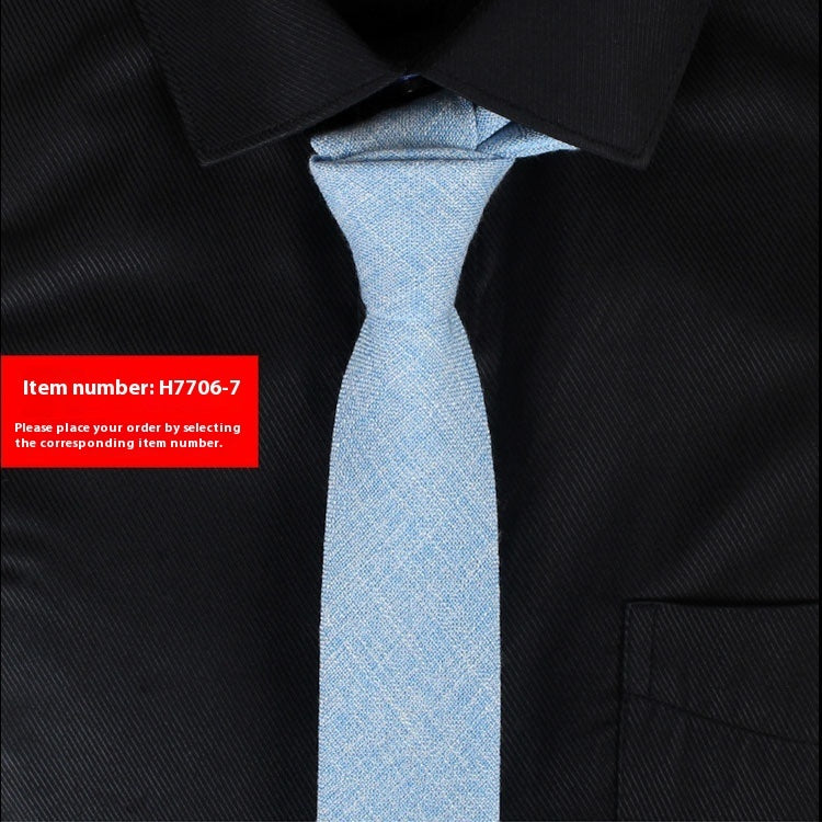 Narrow cotton tie in light blue textured fabric, slim knot.