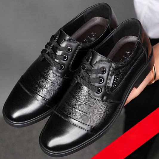 Black leather dress shoes with laces on a gray background
