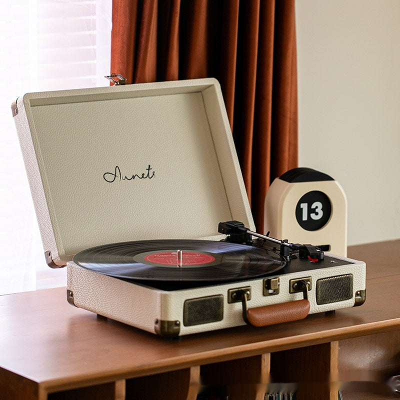 Cream portable Bluetooth record player phonograph with turntable and control knobs