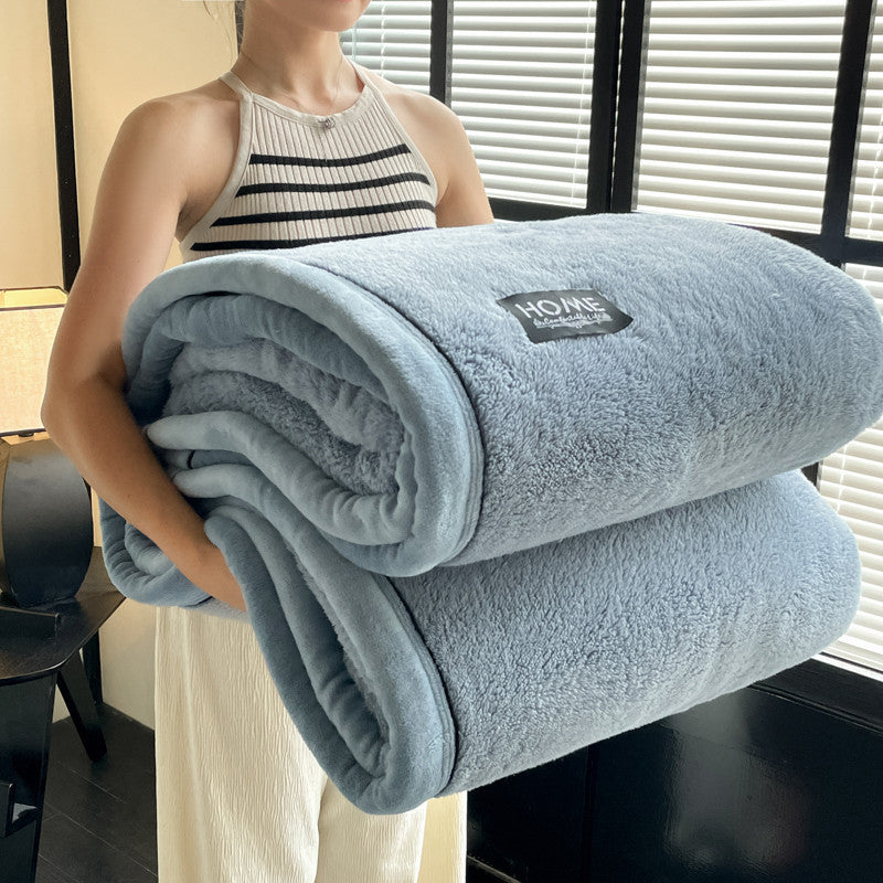 Light blue solid fleece blanket roll with “HOME” patch on the folded top