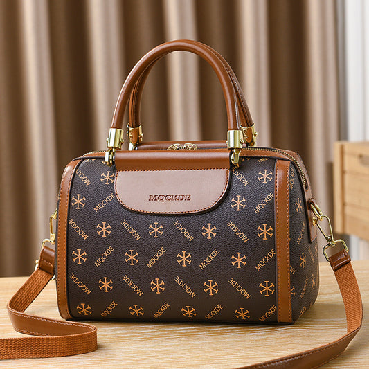 Brown handbag with gold accents on a wooden surface