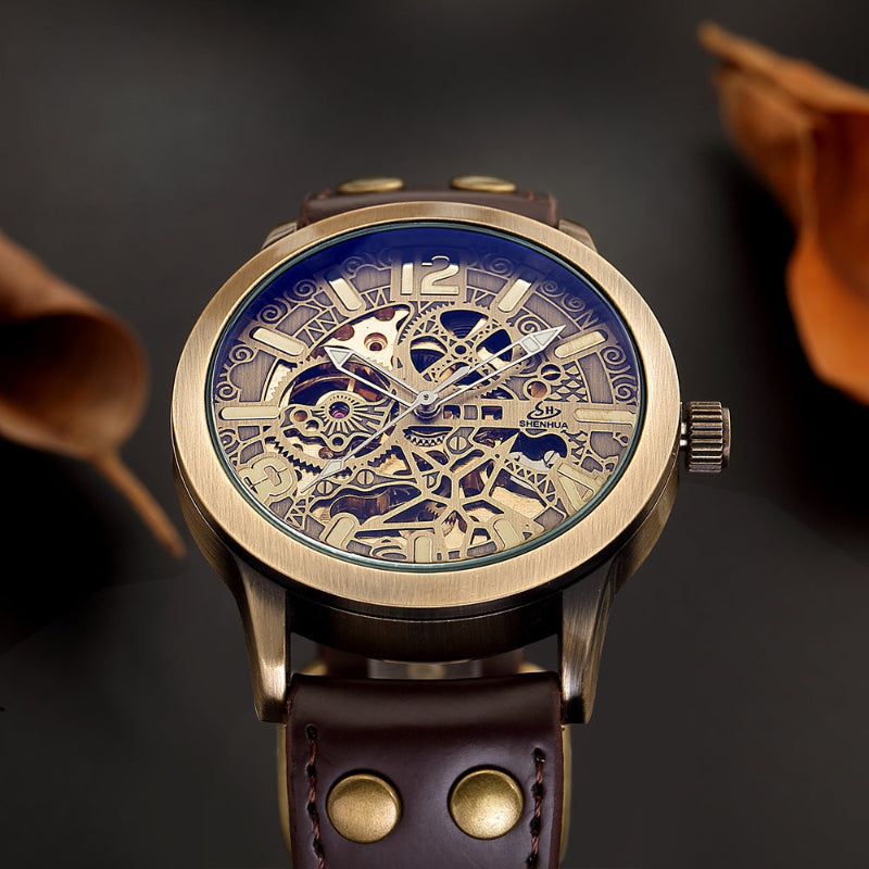 Mechanical watch with dark brown leather strap and blue skeleton dial, gold-tone case