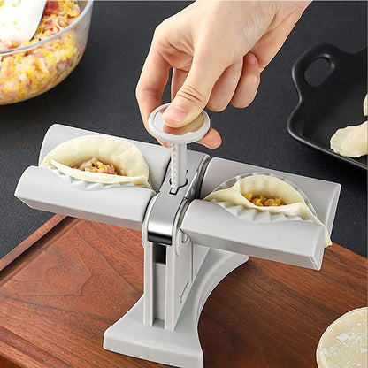 Hand using a dumpling maker to form dumplings on a wooden surface.