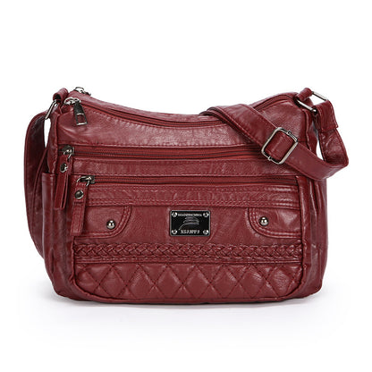 Red leather handbag with multiple pockets and a strap on a white background