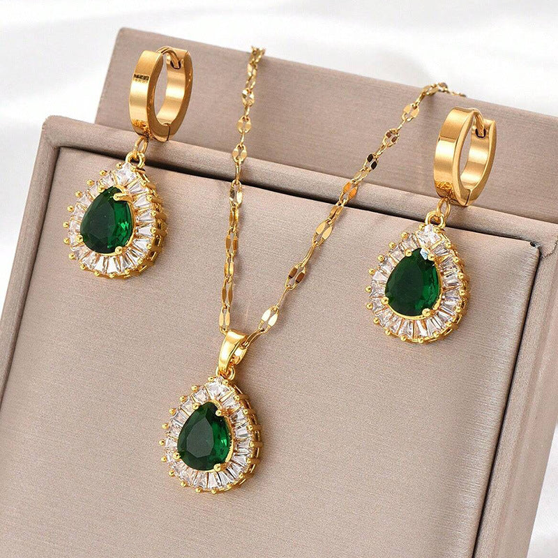 Gold-tone pendant necklace with green teardrop drop earrings, crystal halo settings