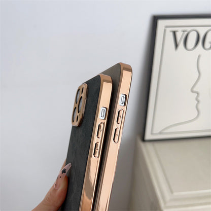 Phone case with rose gold edge held by a hand, Vogue magazine in the background