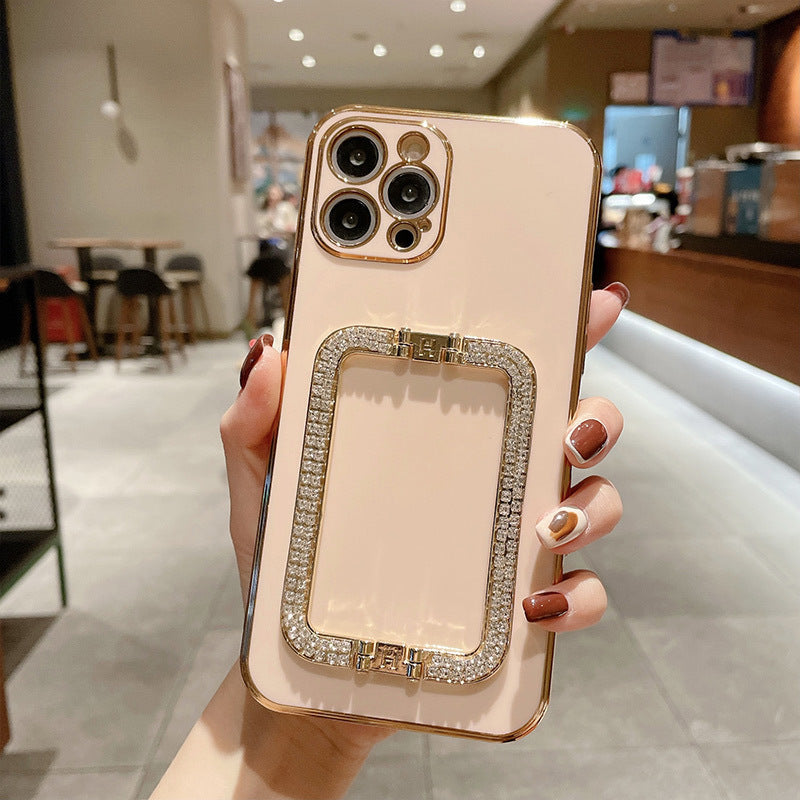 Hand holding a phone case with decorative frame in a store setting