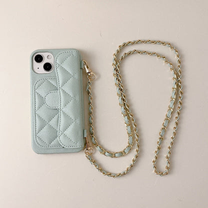 Light blue quilted phone case with a gold chain on a beige background