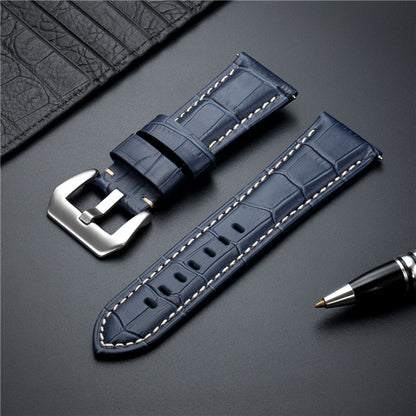 Blue leather watch strap with metal buckle and white contrast stitching.