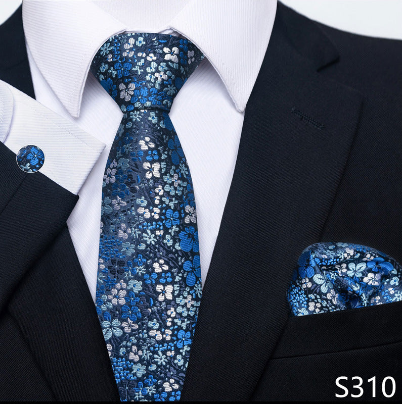 Navy blue floral-pattern tie set with matching pocket square and round cuff links.