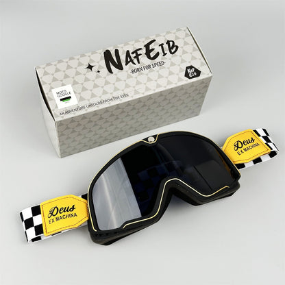 Black goggles with yellow labels and a branded box on a light gray background