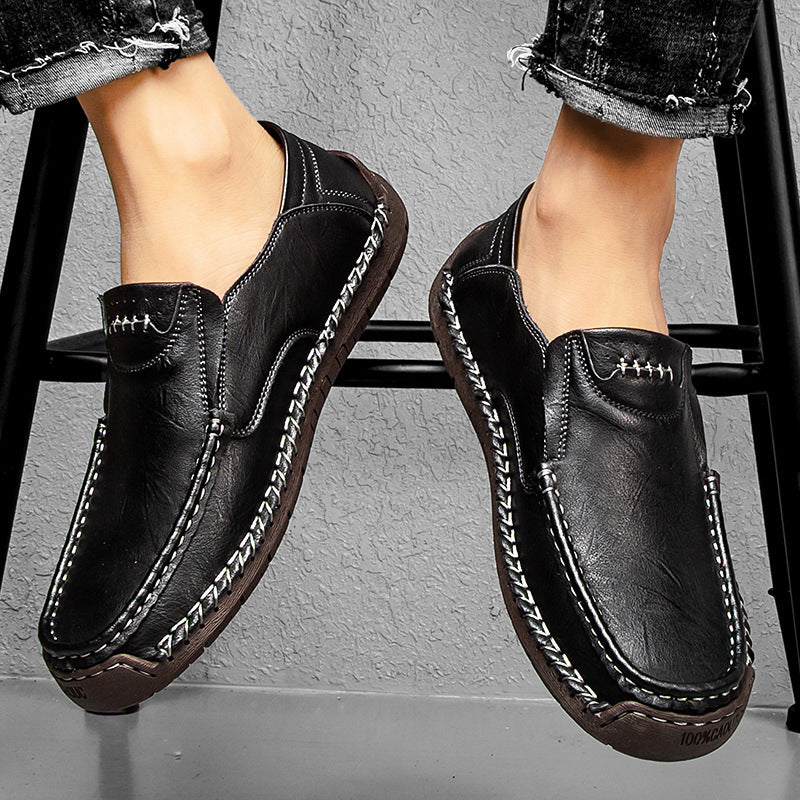 Black leather slip-on loafer with contrast stitching and metal-button detail