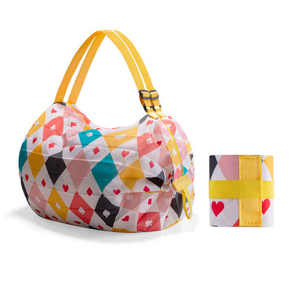 Colorful geometric-patterned handbag with matching wristlet on a white background