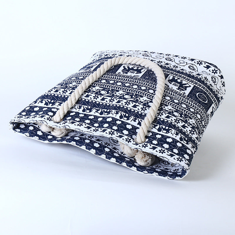 Blue and white printed canvas tote bag lying flat, rope handles visible