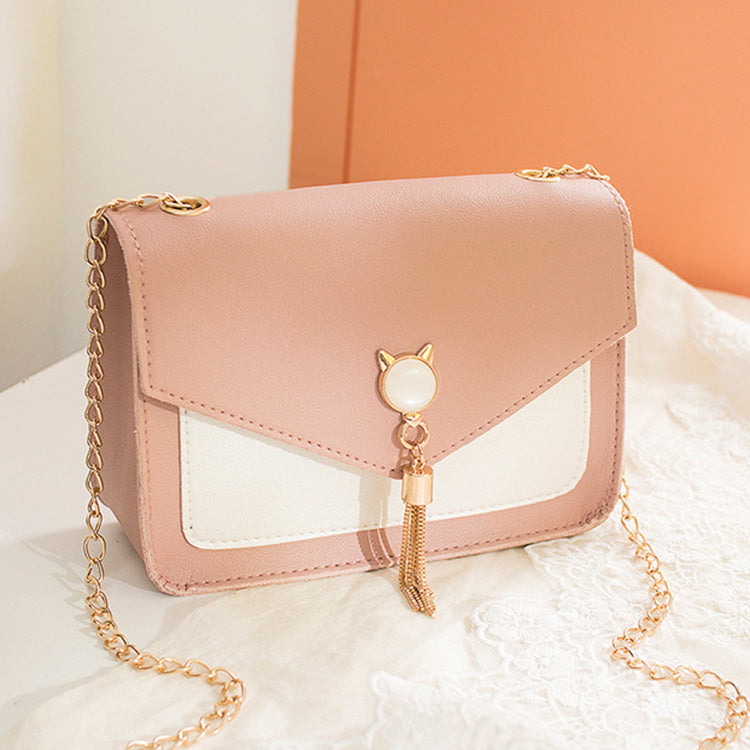 Light pink small square crossbody bag with white insert and gold tassel charm