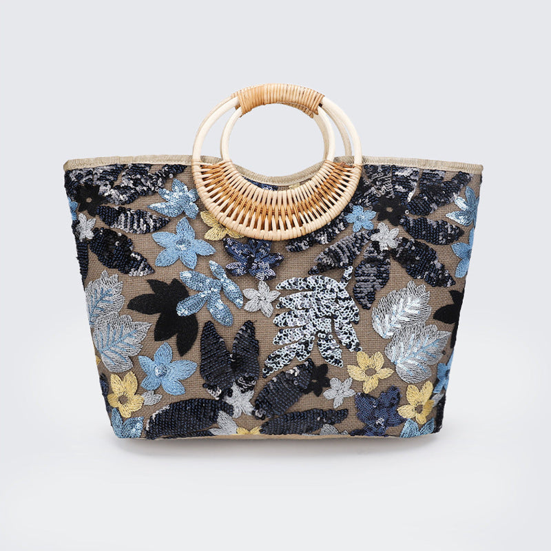 Large woven cotton tote bag with blue floral sequins and rattan half-moon top handle