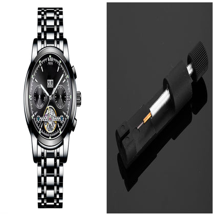 Silver wristwatch with black face and a black tool on a reflective surface