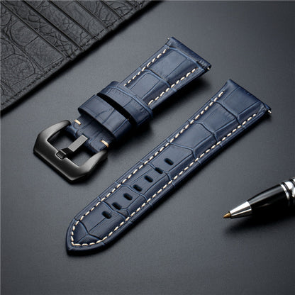 Blue leather watch strap with metal buckle and cream contrast stitching.