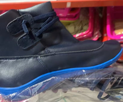 Black high-top sneakers on a reflective surface with a blurred background
