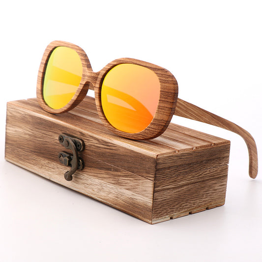 Wooden sunglasses with orange lenses on a wooden stand