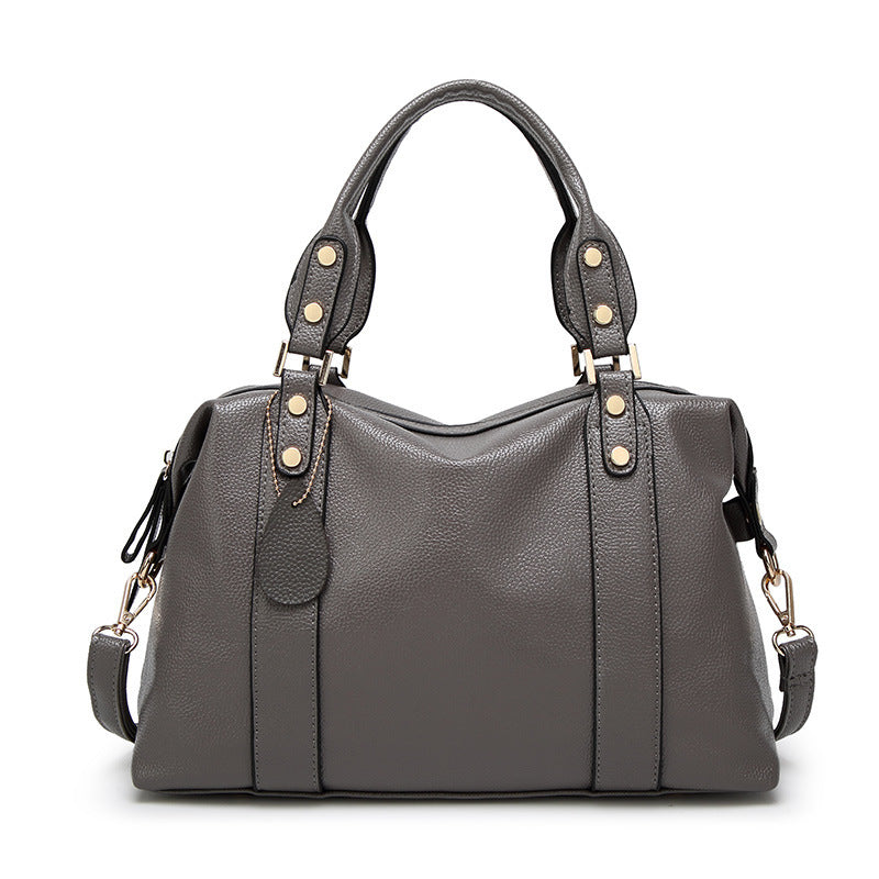 Dark grey PU leather tote handbag with top handles, side tabs, and gold stud accents