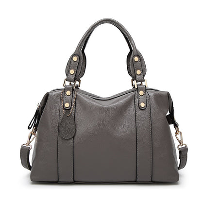 Dark grey PU leather tote handbag with top handles, side tabs, and gold stud accents