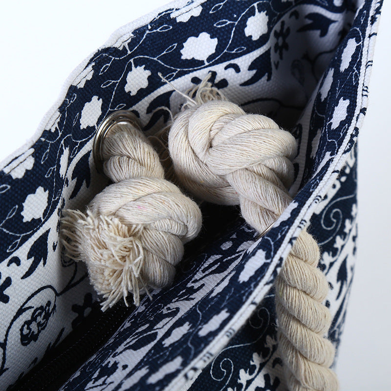 Canvas tote interior showing rope handle and metal ring, blue and white print