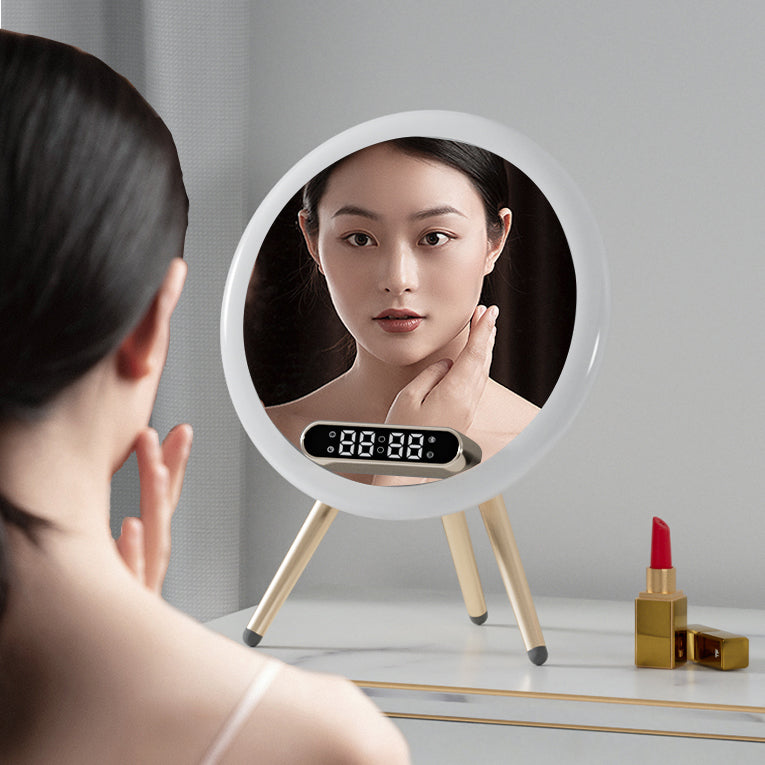 Woman looking at a round mirror with a digital display on a table with makeup items.