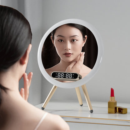 Woman looking at a round mirror with a digital display on a table with makeup items.