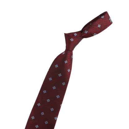 Maroon tie with blue pattern and small gold violin model on a white background