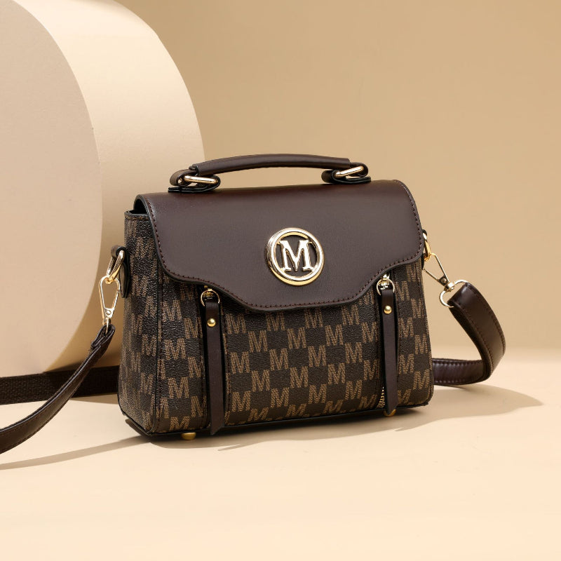 Dark brown and beige monogram crossbody handbag with flap top and gold M emblem