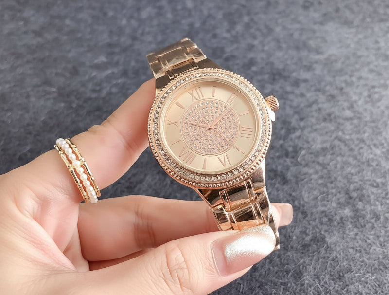 Rose gold bracelet watch with crystal bezel, light dial, and segmented metal link band