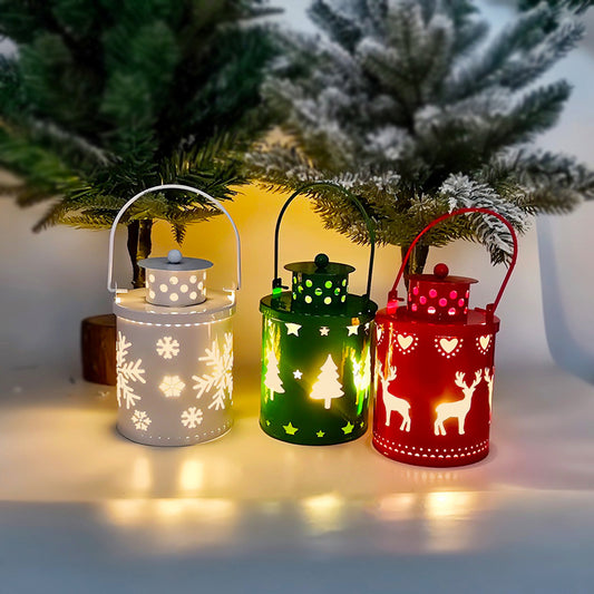 Three decorative lanterns in white, green, and red with Christmas designs, placed against a snowy tree background.