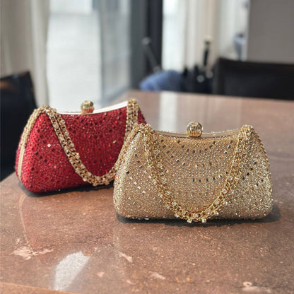 Two glittery handbags, one red and one gold, on a reflective surface.