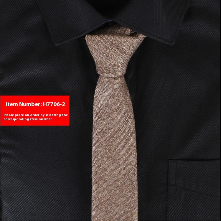 Narrow cotton tie in medium brown tweed texture, slim knot at collar.