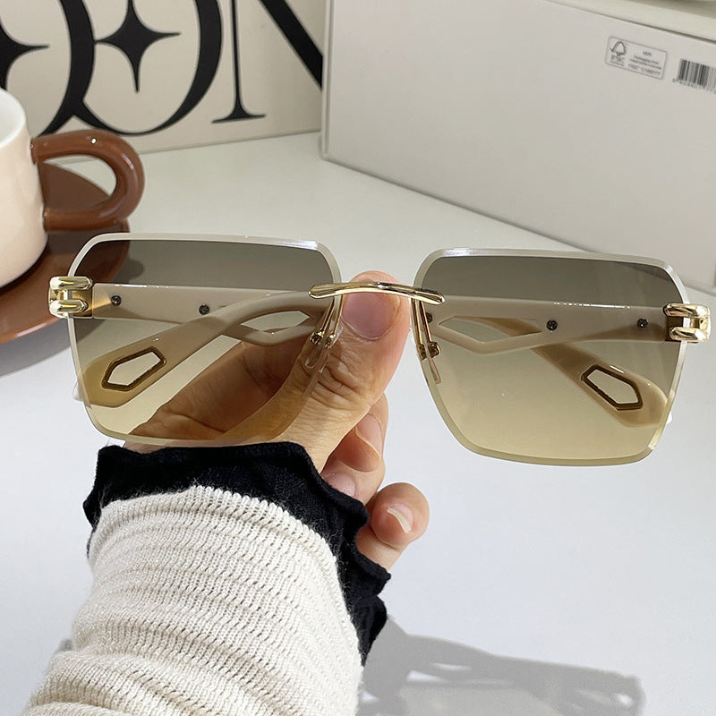 Gold-tone square sunglasses with light gray lenses, geometric cutout temples