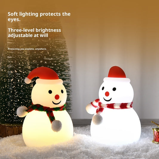 Two illuminated snowmen with red hats and scarves on a snowy ground.