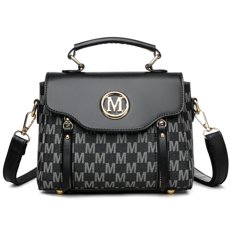Black monogram crossbody handbag with flap top, gold M emblem, side vertical details