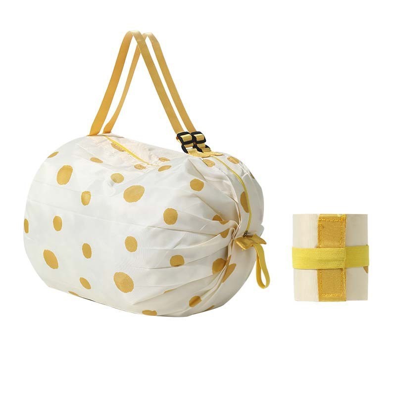 White drawstring bag with gold polka dots and a matching small box on a white background