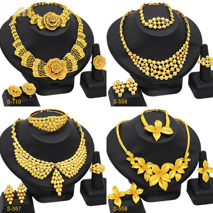 Set of gold jewelry including necklaces, earrings, and rings on black stands.