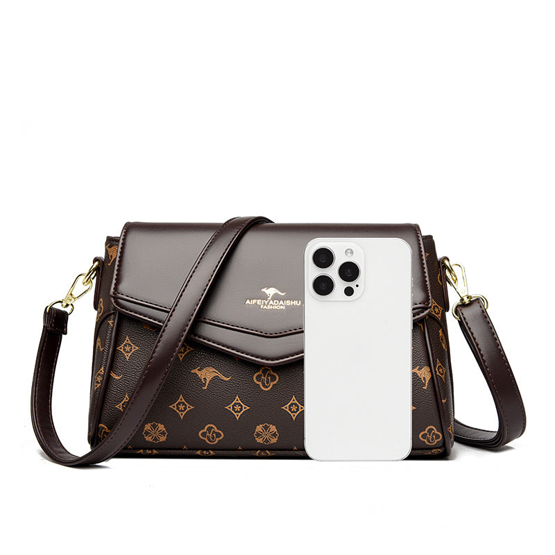 Dark brown monogram crossbody shoulder bag with front flap and gold-tone hardware; phone
