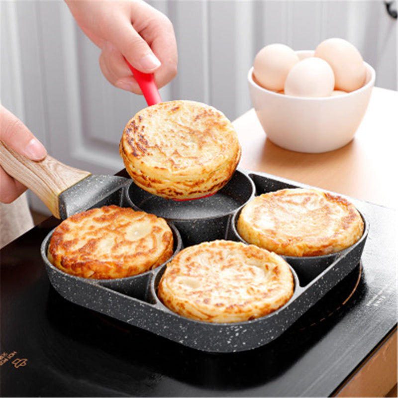 Person using a frying pan with six round compartments to cook small pies or pancakes, with a bowl of eggs in the background.