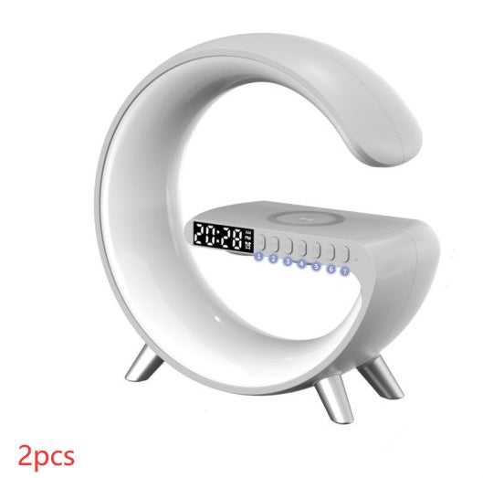 White G-shaped LED lamp with clock display, speaker controls and wireless charging pad