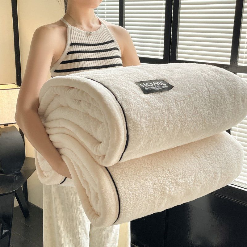 Velvet solid white blanket rolled, plush texture with black-edge trim and HOME label