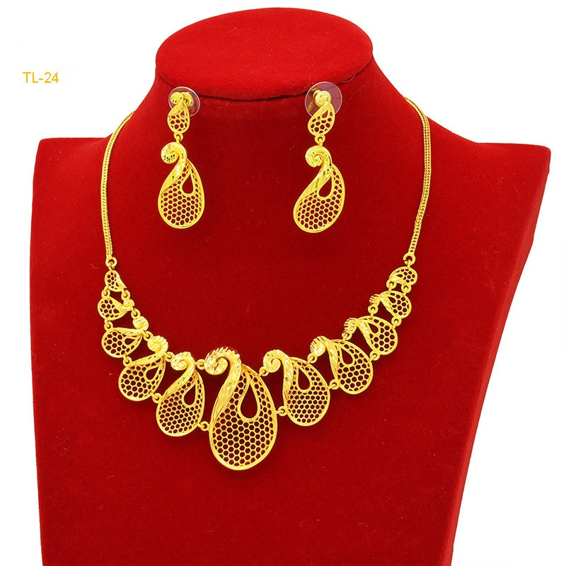 Gold necklace and earrings set on a red velvet stand