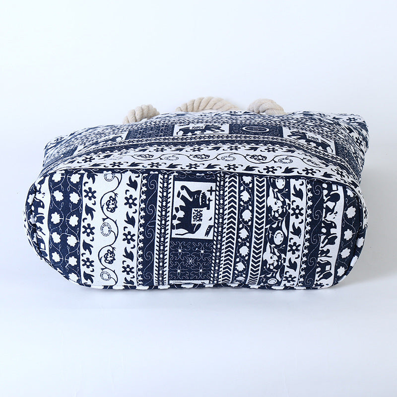 Blue and white printed canvas shoulder tote with rope handles and rounded shape