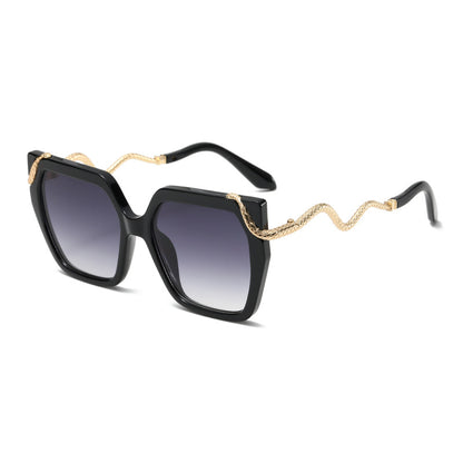 Black sunglasses with gold chain detail on a white background
