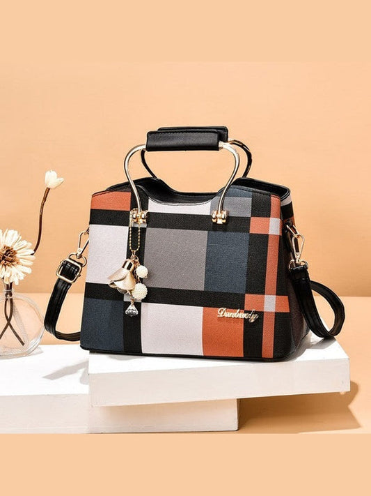 Plaid handbag with top handle, black crossbody strap, gold-tone hardware and charm dangle