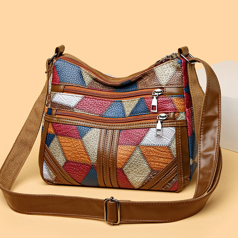 Women's patchwork crossbody bag with brown leather trim and top zip pockets, shoulder strap